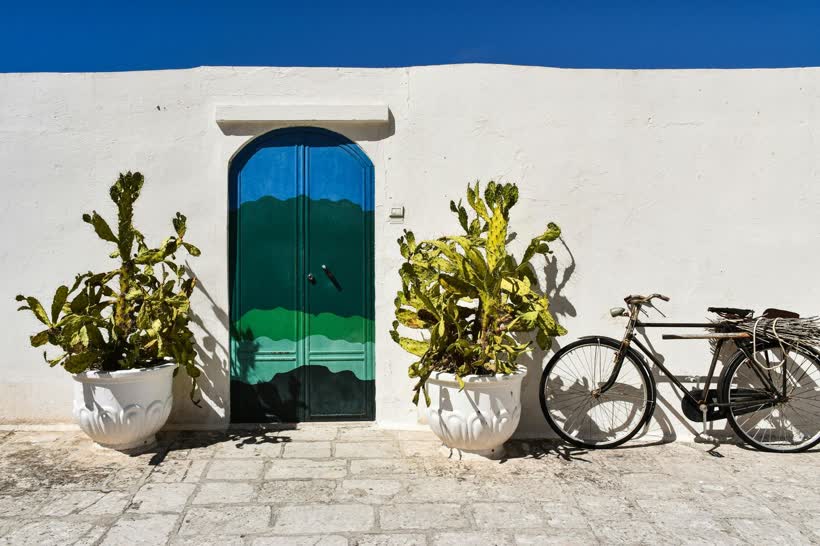 Porta blu e bicicletta in un vicolo pugliese